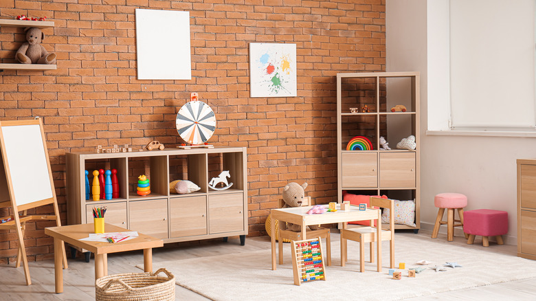 A modern kids playroom with open and closed storage, tables, and toys