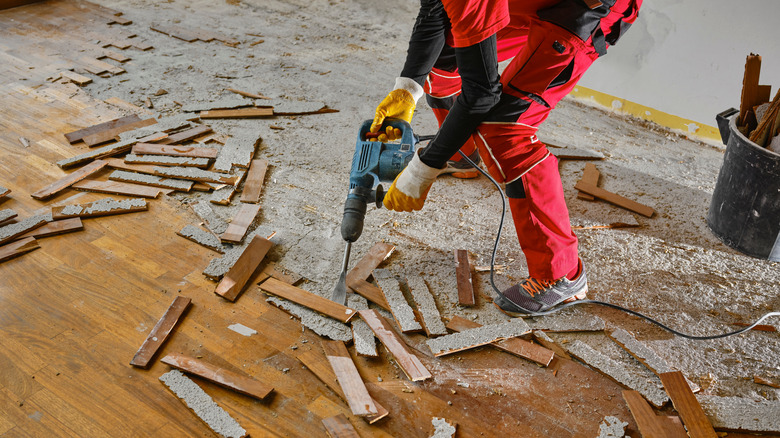 Worker removing wood floor planks