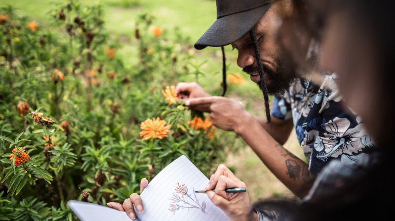 People taking notes on flowers