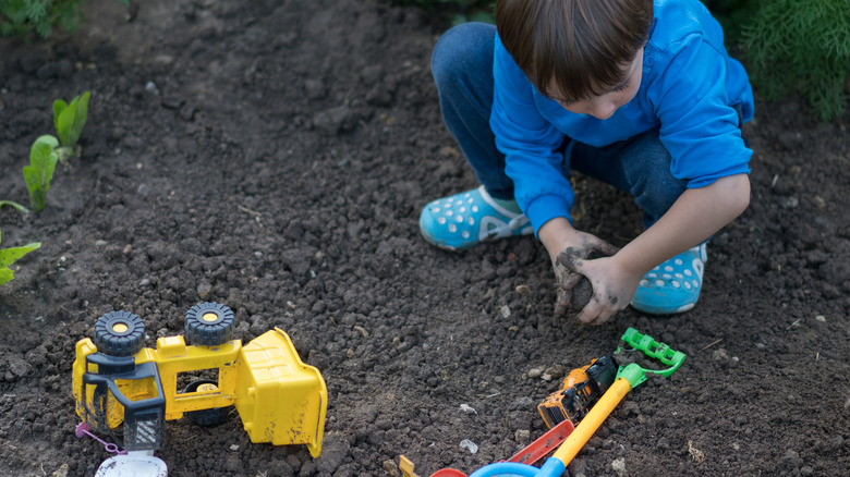 child playing in mud