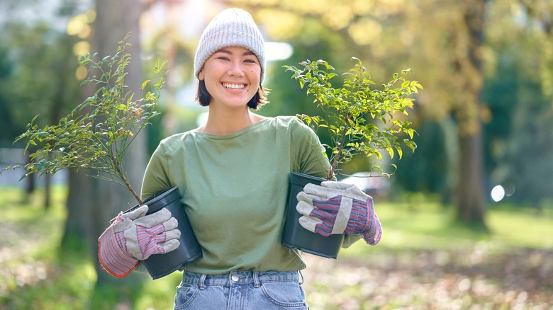 woman holding two potted plants