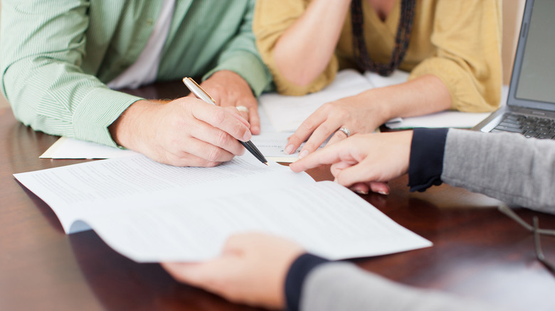 People signing paperwork with realtor