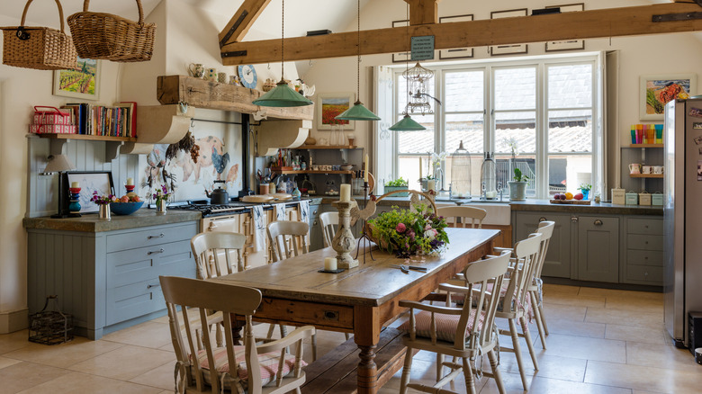 Vintage farmhouse table in rustic kitchen with green pendant light