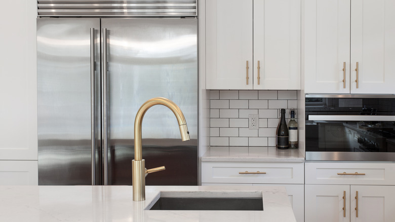 White kitchen built with shaker style cabinets and white granite