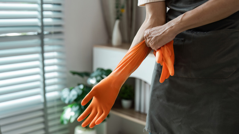 Person putting on thick orange rubber gloves