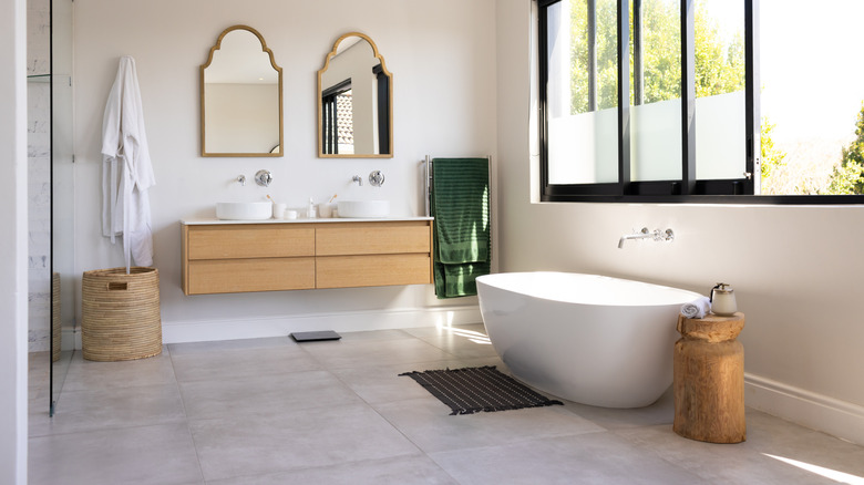 Large tiles on floor in a spacious bathroom with neutral decor