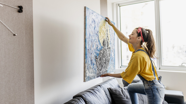 Woman hanging a picture