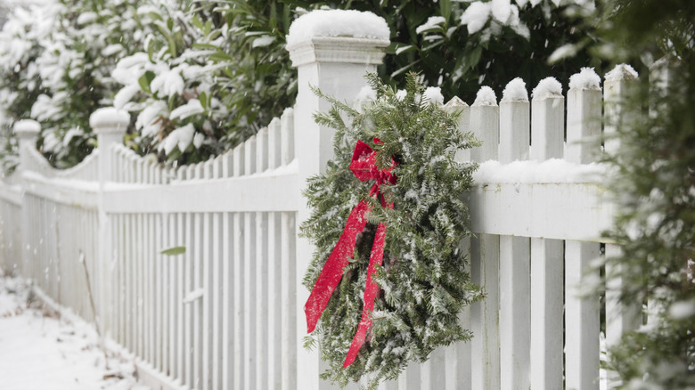 A white picket fence with a wreath on it