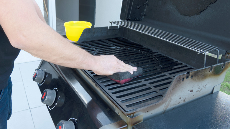 person cleaning a grill 