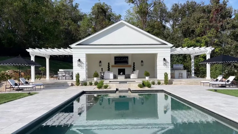 outdoor fireplace with seating and pool