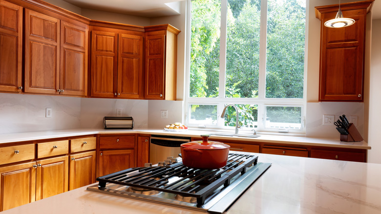 A kitchen with cherry wood cabinets.