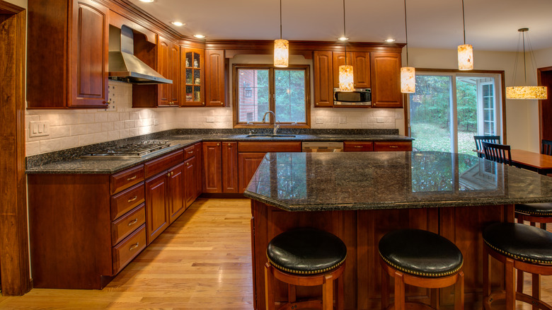 A spacious kitchen with dark cherry wood cabinets.