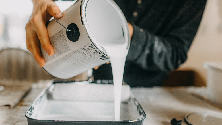 person pouring out white paint