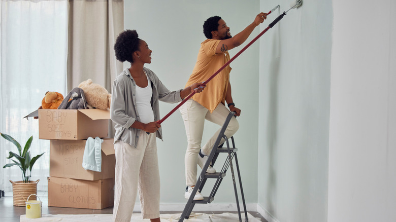 Couple painting room together