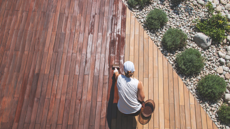 Woman staining a deck