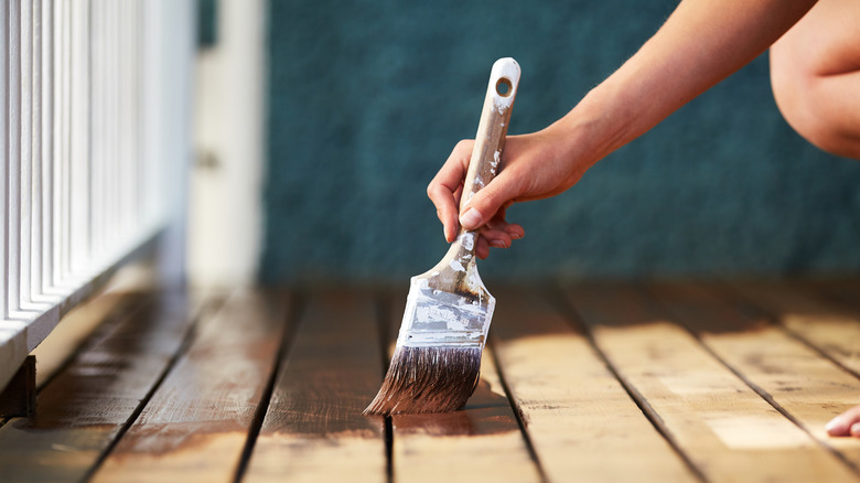 Person staining a deck