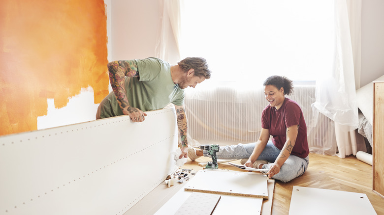 Father and daughter assembling IKEA shelf