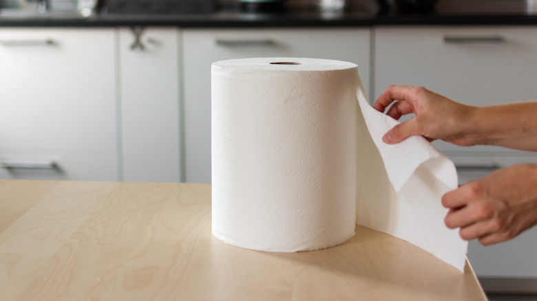 Person tearing paper towel sheet