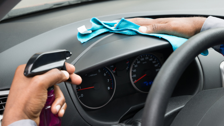 Person cleaning car dashboard