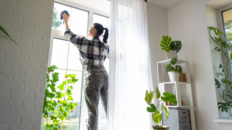 person wiping window with rag