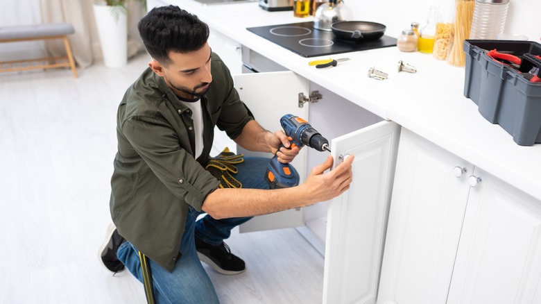 Man installing cabinet doors