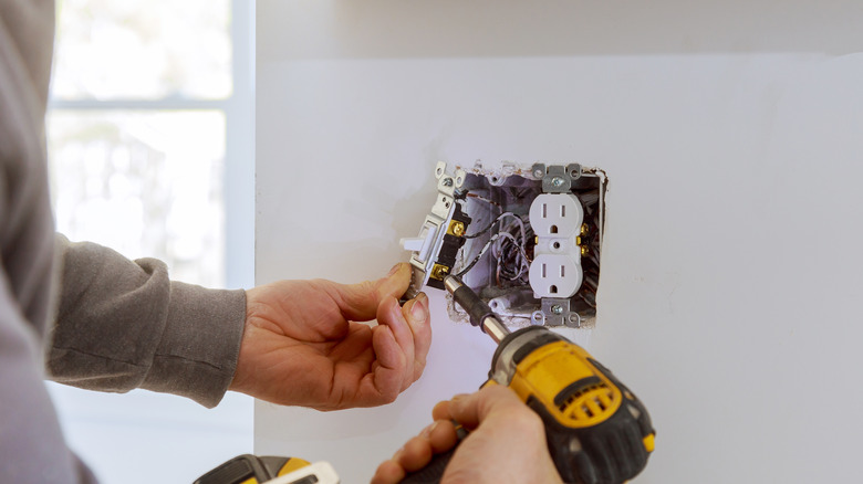 Person installing an electrical outlet