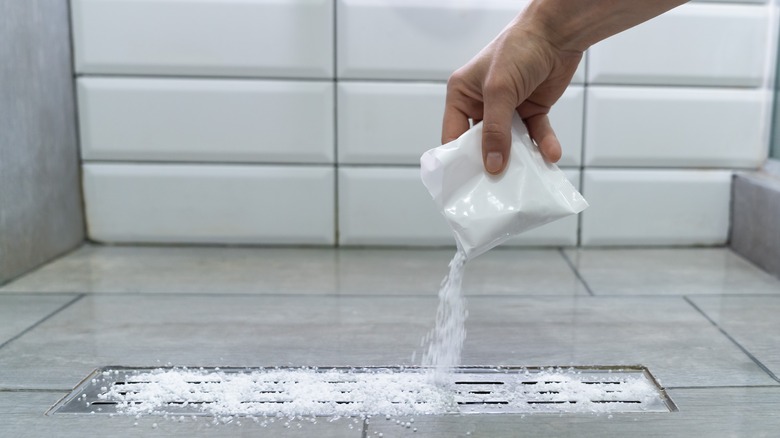 person cleaning bathroom drain