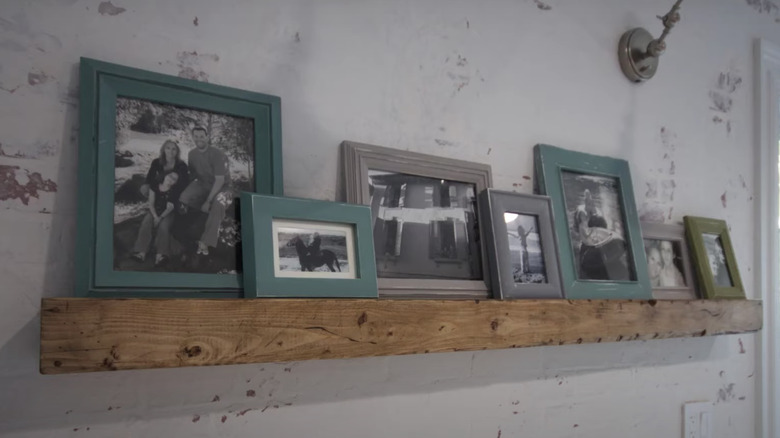 wooden mantel with framed photographs