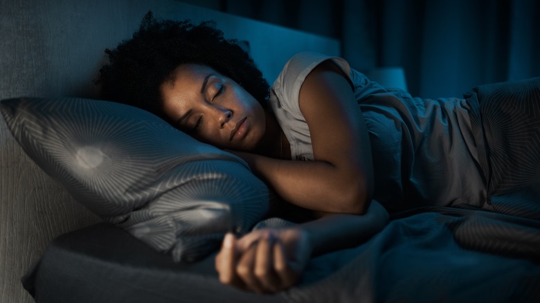 Woman sleeping on black bedding