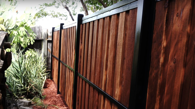 A fence made from square steel pipe and wood planks.