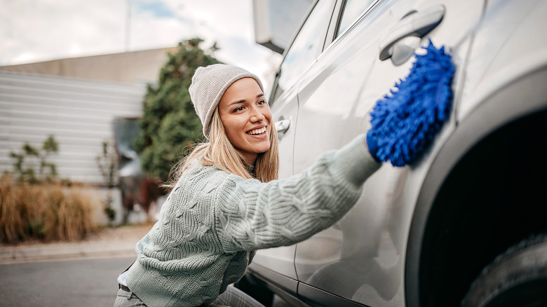 Woman washing car exterior