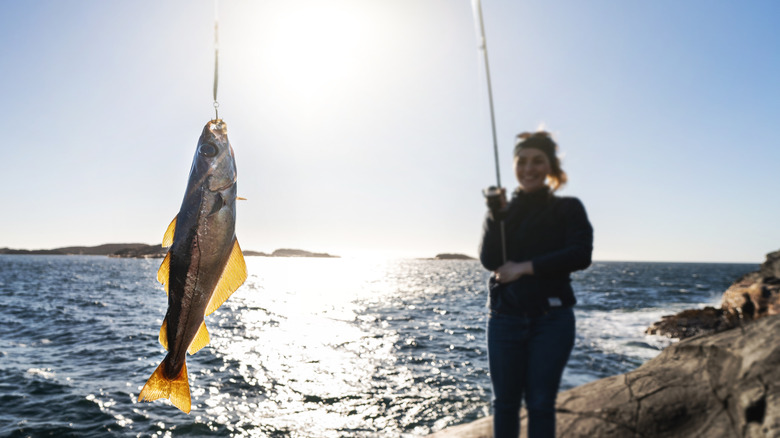 Woman holding a rod and large fish