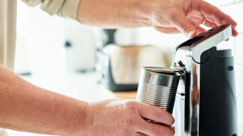 Man using electric can opener