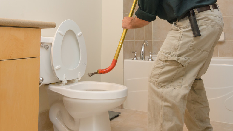 man using toilet auger