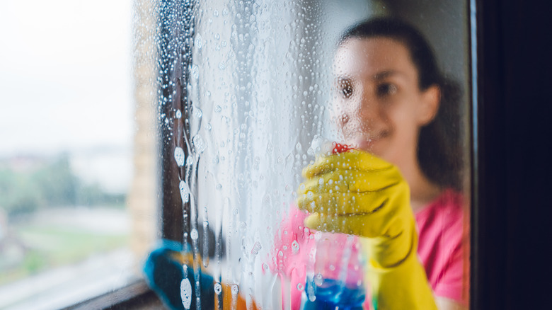 Woman cleaning glass window