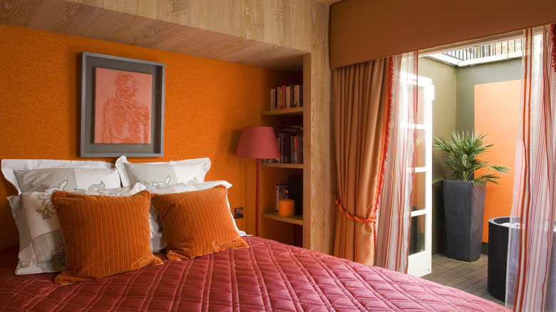 bedroom with orange pillows and wall