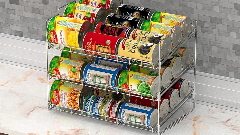 rolling can organizer on stone countertop with canned fruits, soups, and vegetables