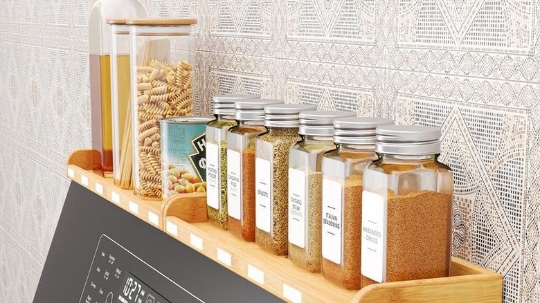 kitchen spices and ingredients above electronic stove panel on stove shelf