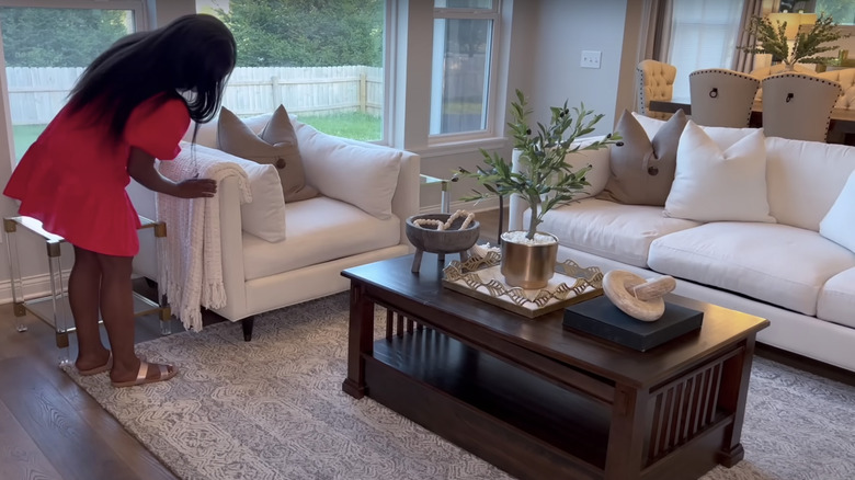 young woman decorating white couches