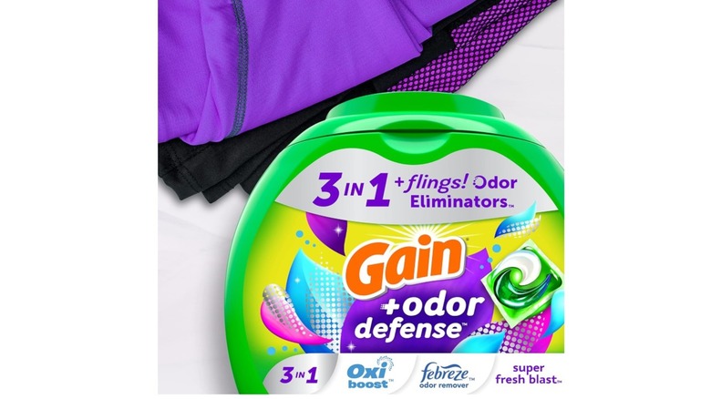 A package of Gain + Odor Defense Laundry Pods near folded laundry