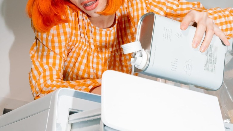 A woman pouring DedCool detergen into the washer