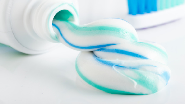 Toothpaste and tube on white table