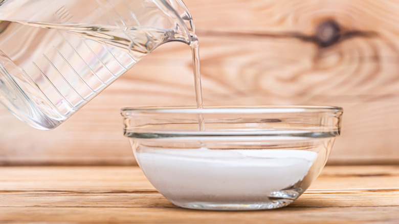 Pouring water in a bowl containing baking soda