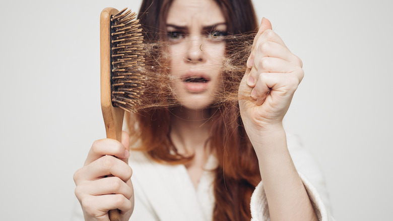 Woman pulling hair from brush