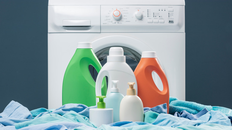 Bottles of detergent in front of washer