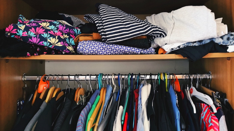 A closet full of colorful clothes hanging up and folded