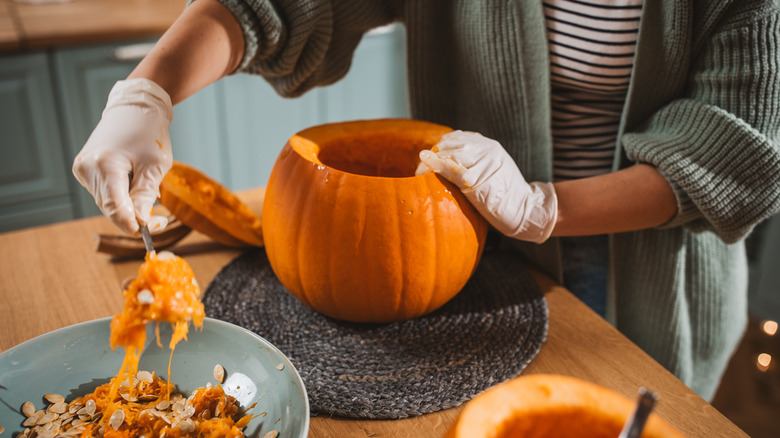 person scooping pumpkin seeds