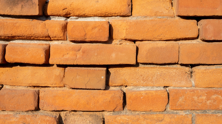 A brick wall with bulging damage