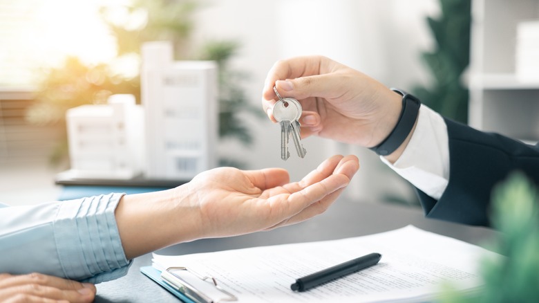 Seller handing home key to buyer