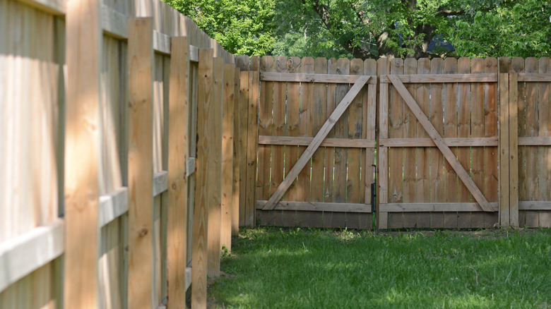 A wooden fence with a double gate